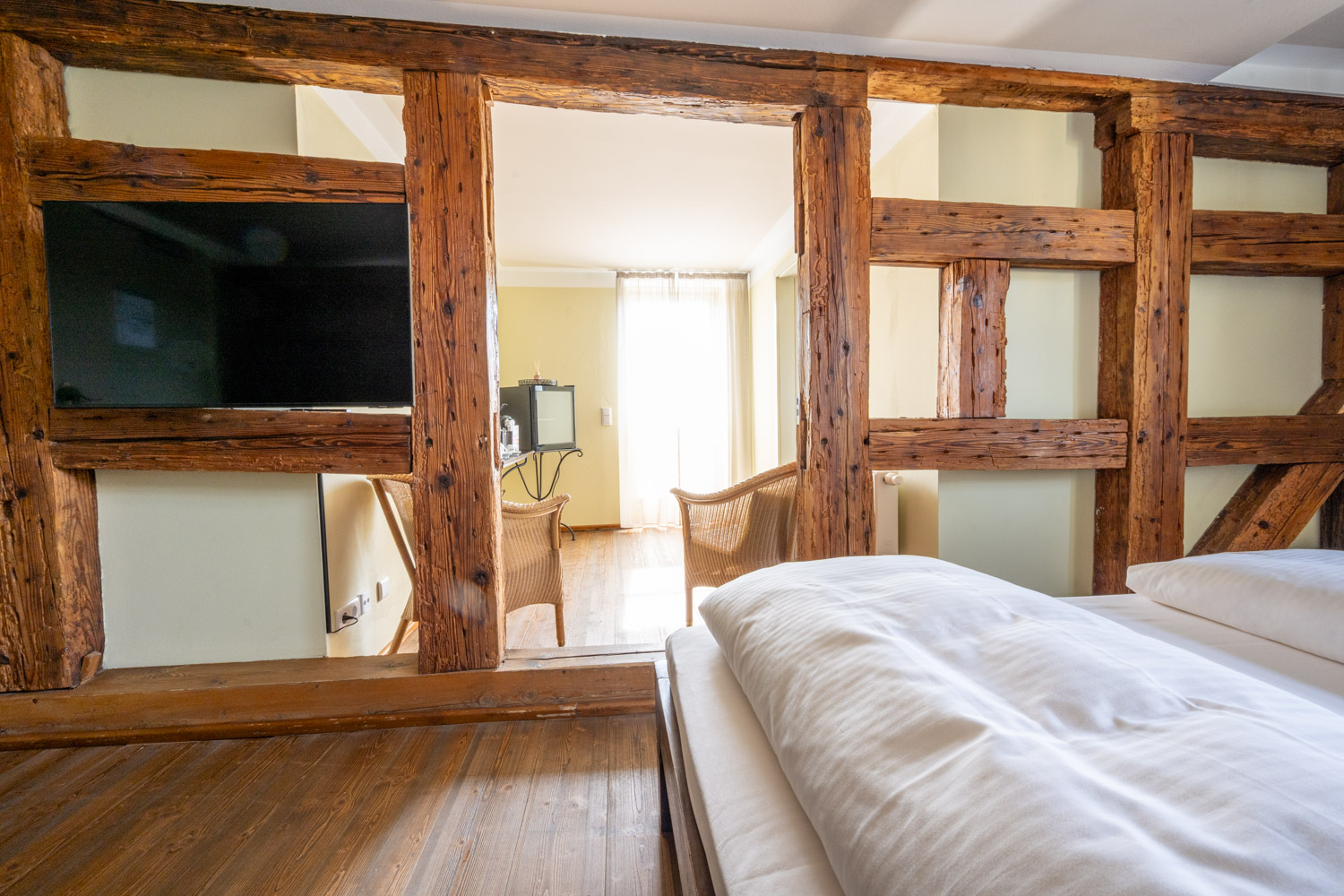 [Doppelzimmer 102] Helles Doppelzimmer im Alten Fährgut mit gemütlichem Doppelbett, direktem Zugang zur gemeinsamen Terrasse und weitem Blick über Elbe und Blaues Wunder.