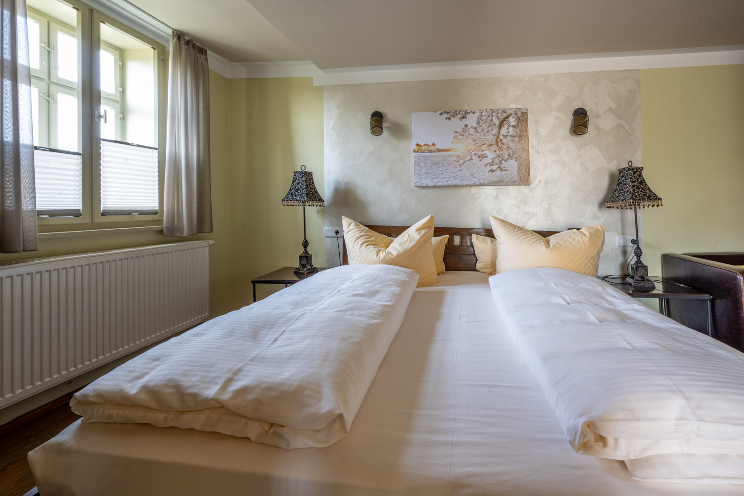 [Doppelzimmer 102] Helles Doppelzimmer im Alten Fährgut mit gemütlichem Doppelbett, direktem Zugang zur gemeinsamen Terrasse und weitem Blick über Elbe und Blaues Wunder.