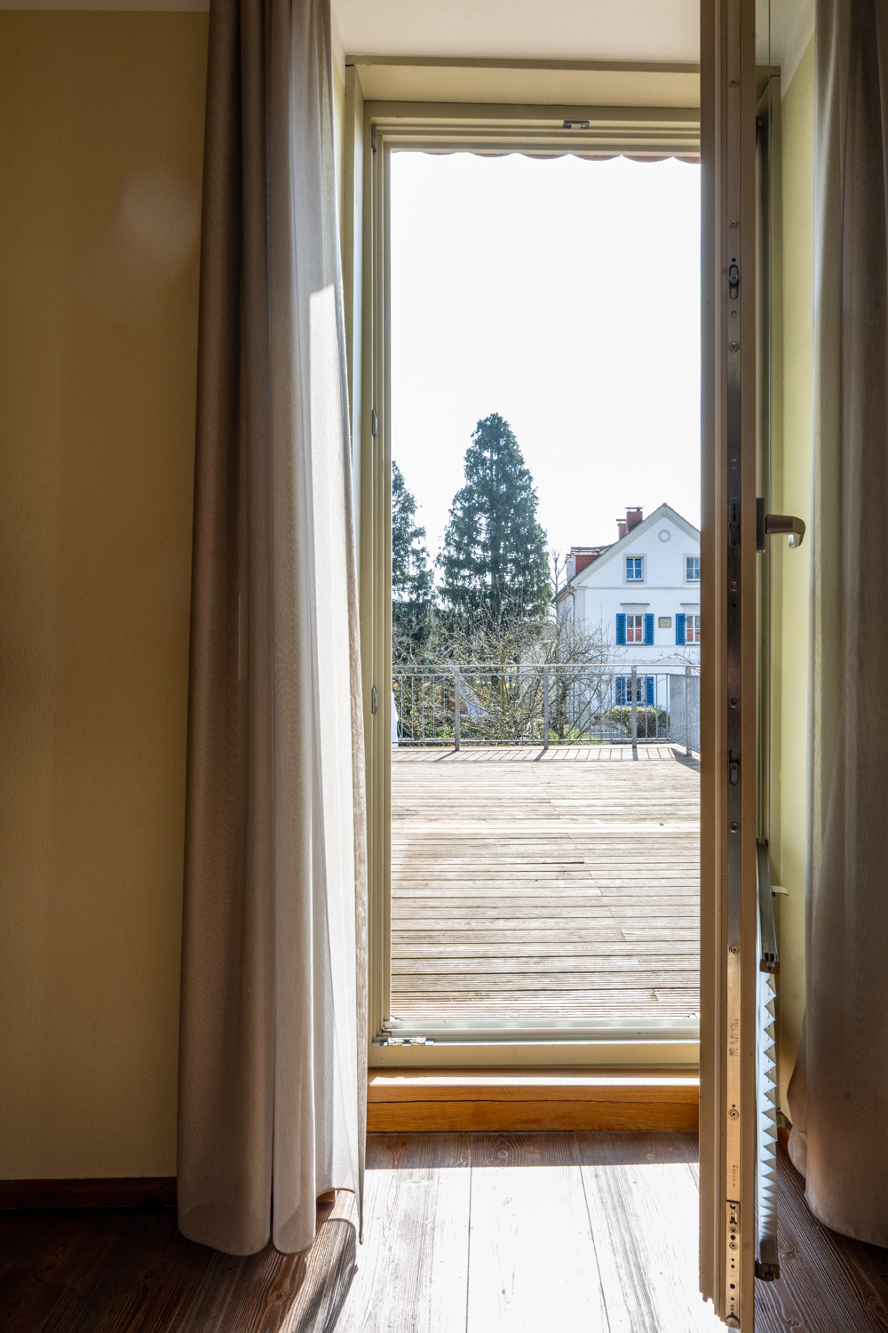 [Doppelzimmer 102] Helles Doppelzimmer im Alten Fährgut mit gemütlichem Doppelbett, direktem Zugang zur gemeinsamen Terrasse und weitem Blick über Elbe und Blaues Wunder.