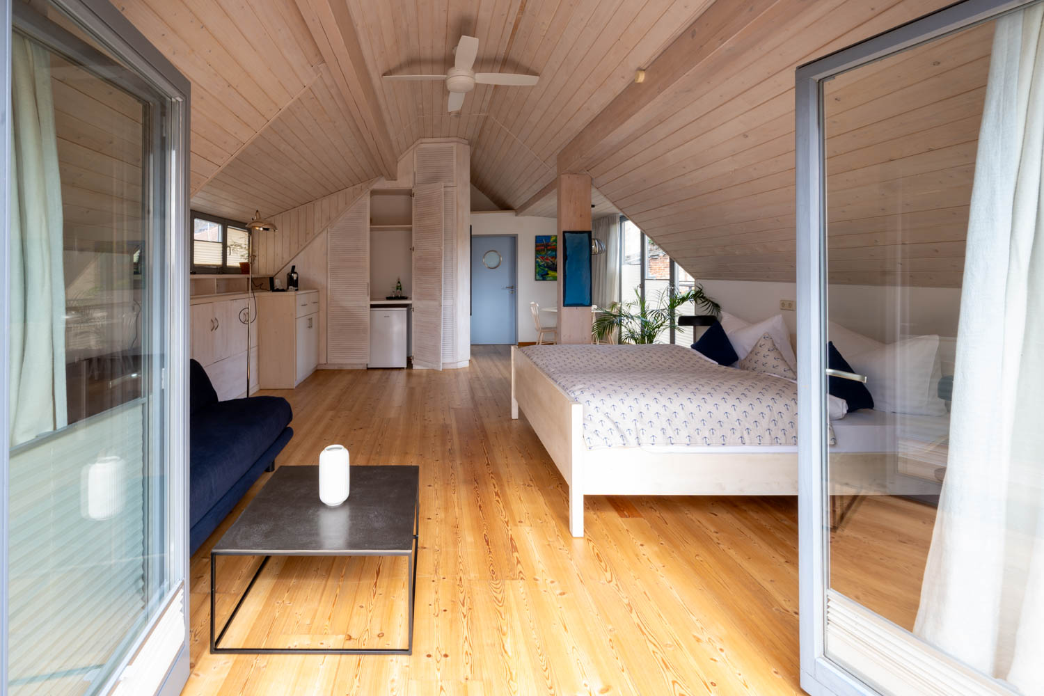 [Doppelzimmer Kajüte 401] Freundliches Doppelzimmer im Neuen Fährgut mit gemütlichem Doppelbett, kleiner Küche und großer Süd-Terrasse mit Blick auf die Elbe.