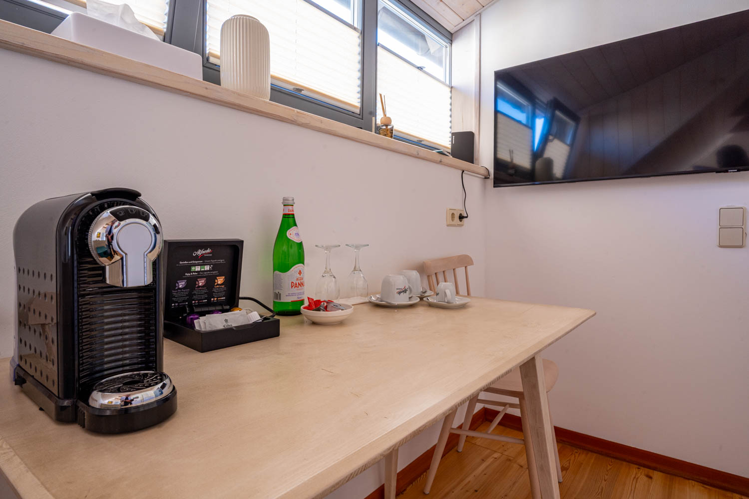 [Doppelzimmer »Koje 1« 402] Helles Doppelzimmer im Neuen Fährgut mit gemütlichem Doppelbett, Blick auf die Dorfstraße zur Elbe und Zugang zur gemeinsamen Terrasse mit Zimmer 403.