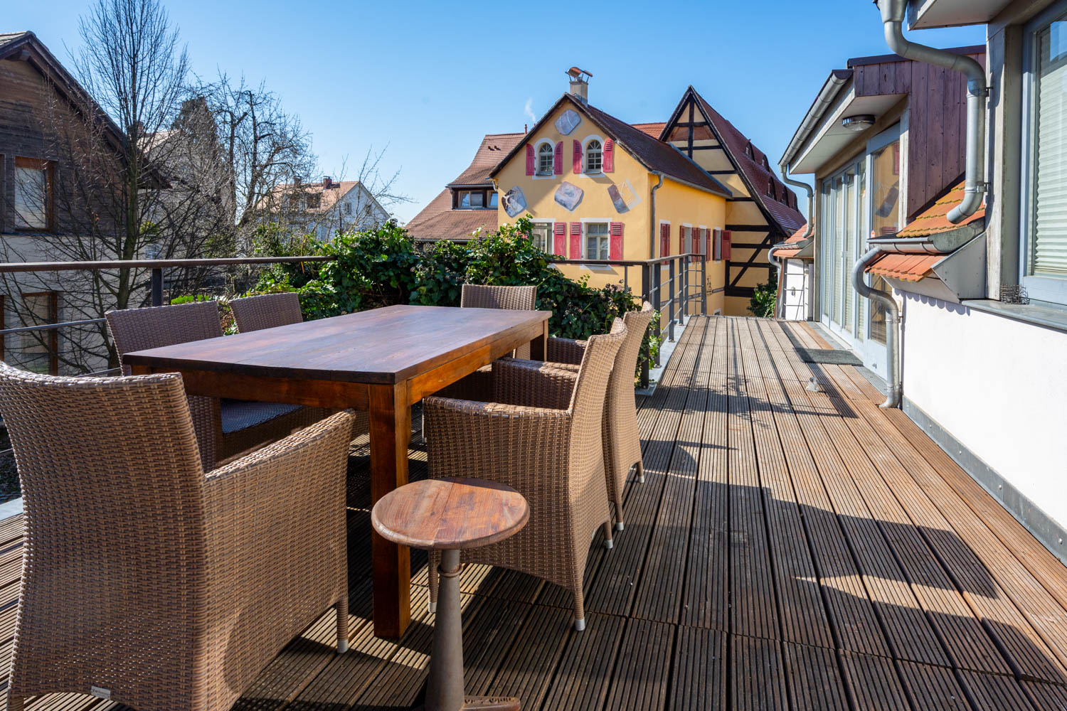 [Doppelzimmer »Koje 1« 402] Helles Doppelzimmer im Neuen Fährgut mit gemütlichem Doppelbett, Blick auf die Dorfstraße zur Elbe und Zugang zur gemeinsamen Terrasse mit Zimmer 403.