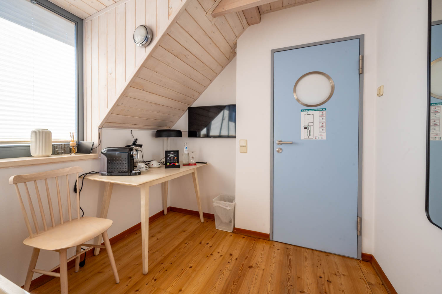[Einzelzimmer »Koje 2« 403] Helles Einzelzimmer im Neuen Fährgut mit bequemem Bett, Blick auf die Dorfstraße zur Elbe und Zugang zur gemeinsamen Terrasse mit Koje 1.