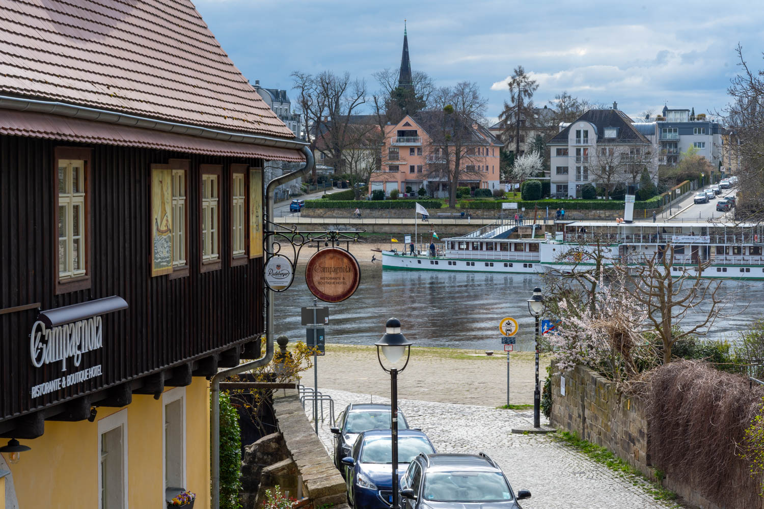 [Einzelzimmer »Koje 2« 403] Helles Einzelzimmer im Neuen Fährgut mit bequemem Bett, Blick auf die Dorfstraße zur Elbe und Zugang zur gemeinsamen Terrasse mit Koje 1.