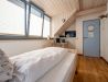 [Einzelzimmer »Koje 2« 403] Helles Einzelzimmer im Neuen Fährgut mit bequemem Bett, Blick auf die Dorfstraße zur Elbe und Zugang zur gemeinsamen Terrasse mit Koje 1.