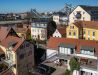 [Doppelzimmer »Koje 1« 402] Helles Doppelzimmer im Neuen Fährgut mit gemütlichem Doppelbett, Blick auf die Dorfstraße zur Elbe und Zugang zur gemeinsamen Terrasse mit Zimmer 403.
