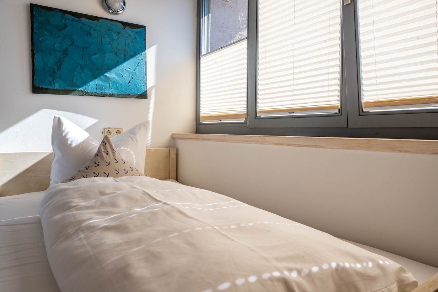 [Einzelzimmer »Koje 2« 403] Helles Einzelzimmer im Neuen Fährgut mit bequemem Bett, Blick auf die Dorfstraße zur Elbe und Zugang zur gemeinsamen Terrasse mit Koje 1.