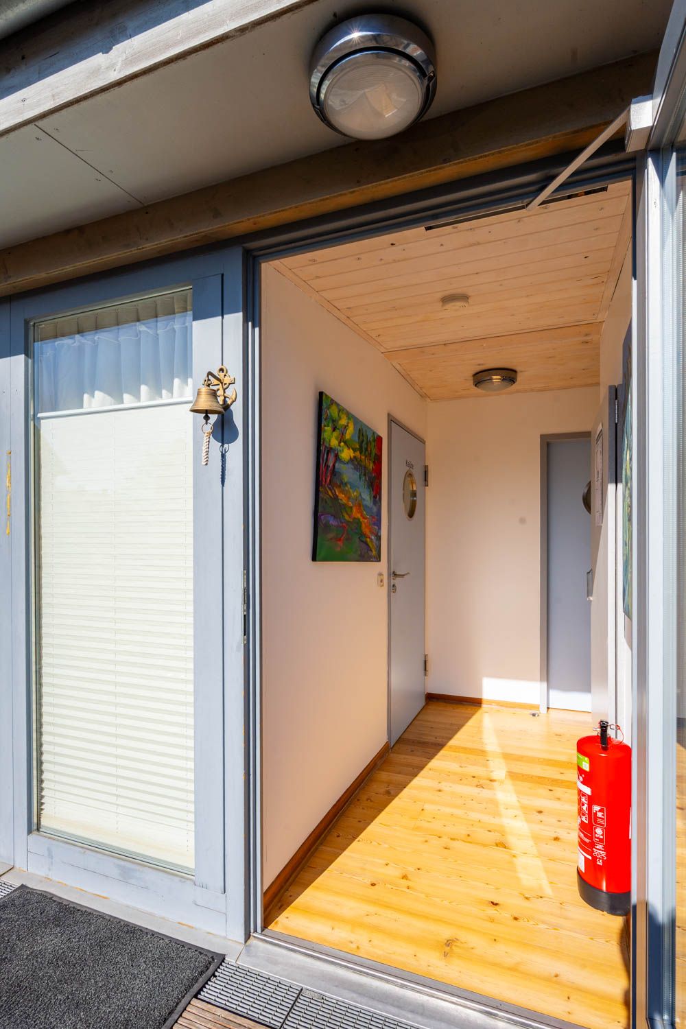 [Einzelzimmer »Koje 2« 403] Helles Einzelzimmer im Neuen Fährgut mit bequemem Bett, Blick auf die Dorfstraße zur Elbe und Zugang zur gemeinsamen Terrasse mit Koje 1.