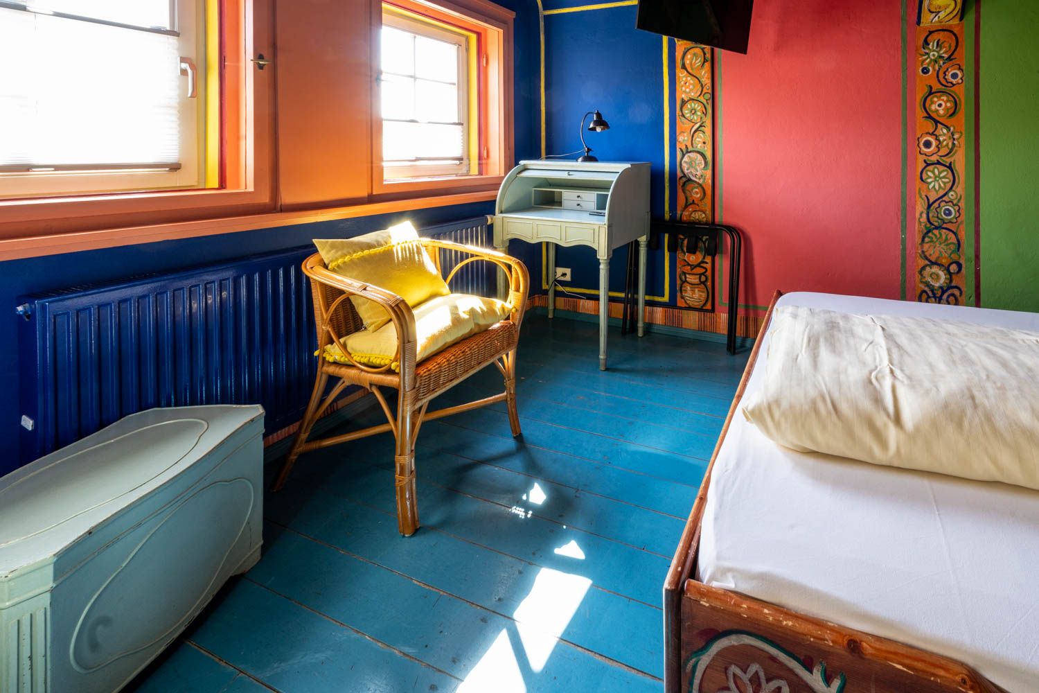 [Einzelzimmer 203 Böckstiegel] Kompaktes Einzelzimmer mit künstlerisch gestalteten Böckstiegel-Wänden, bequemen Bett und liebevollen Details im historischen Alten Fährgut.