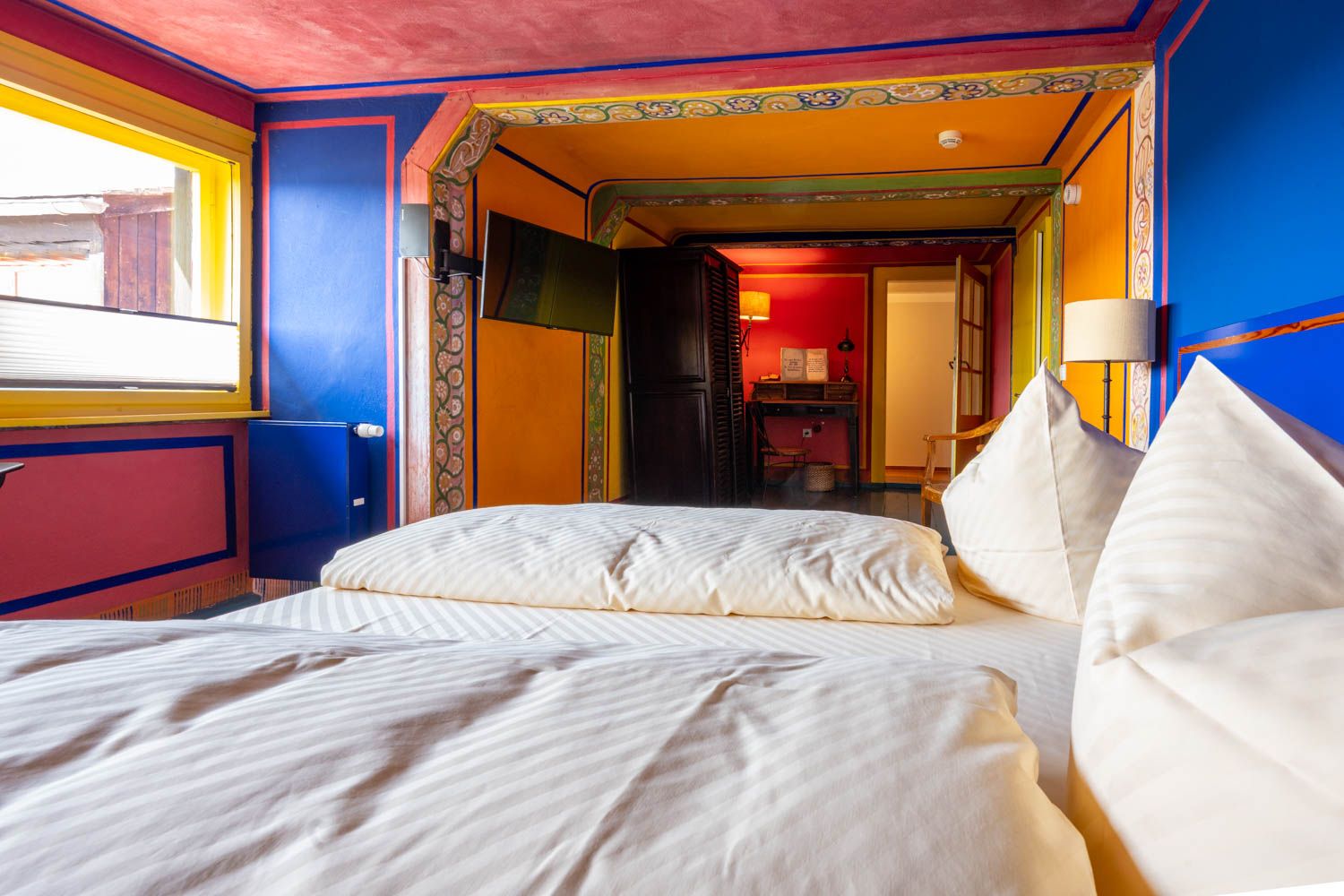 [Böckstiegel-Doppelzimmer 202] Individuell ausgemaltes Doppelzimmer mit künstlerischen Böckstiegel-Elementen, gemütlichem Doppelbett und liebevollen Details im historischen Alten Fährgut.