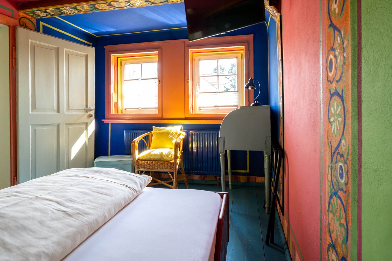 [Einzelzimmer 203 Böckstiegel] Kompaktes Einzelzimmer mit künstlerisch gestalteten Böckstiegel-Wänden, bequemen Bett und liebevollen Details im historischen Alten Fährgut.