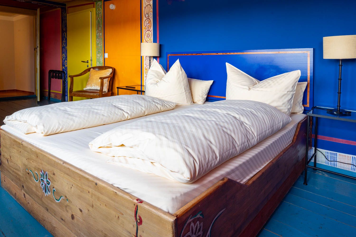 [Böckstiegel-Doppelzimmer 202] Individuell ausgemaltes Doppelzimmer mit künstlerischen Böckstiegel-Elementen, gemütlichem Doppelbett und liebevollen Details im historischen Alten Fährgut.